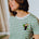 Person wearing a green and white striped t-shirt with a toucan design.