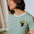 Person wearing a green and white striped t-shirt with a toucan design.