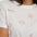 White t-shirt with red embroidered designs on a person wearing it.