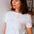 Woman wearing a white t-shirt with red patterns in a casual setting
