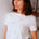 Woman wearing a white t-shirt with red patterns in a casual setting