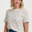 a woman wearing a white tshirt with concenteic circle print 