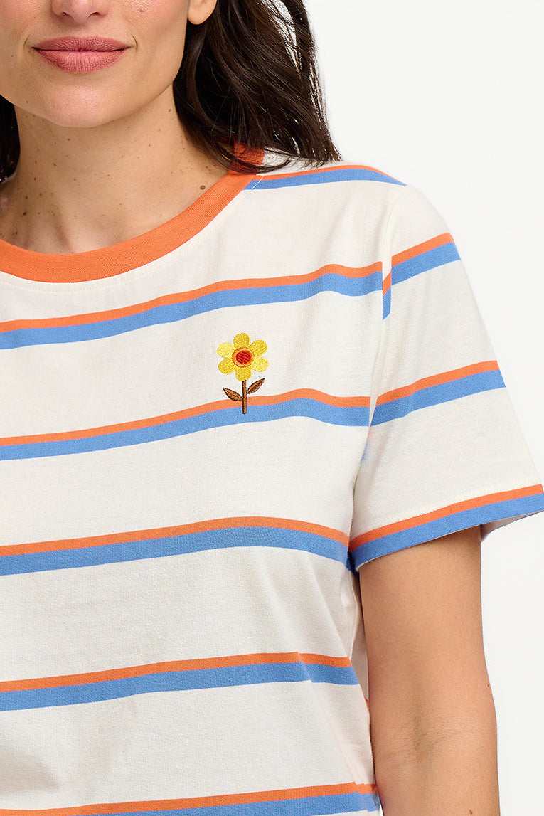 Person wearing a striped shirt with a flower design, standing