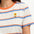 Person wearing a striped shirt with a flower design, standing