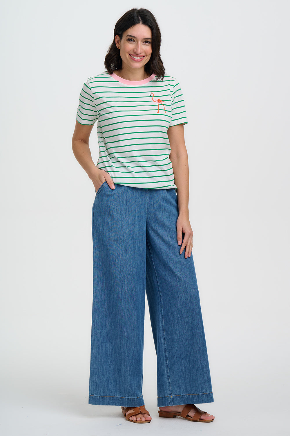 Woman wearing a striped shirt and wide-leg jeans on a white background