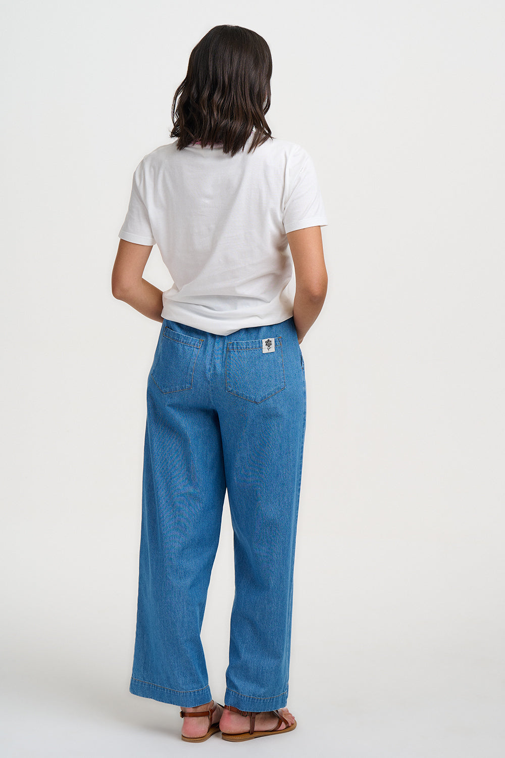 Person wearing a white t-shirt and blue jeans on a white background