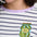 Person wearing a white and navy striped shirt with a pickle jar patch.