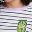 Person wearing a white and navy striped shirt with a pickle jar patch.
