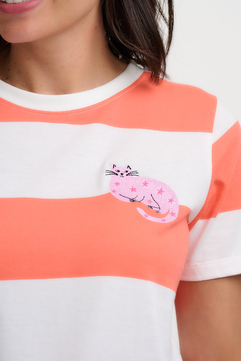 Close-up of a person wearing a striped shirt with a cat design on a white background