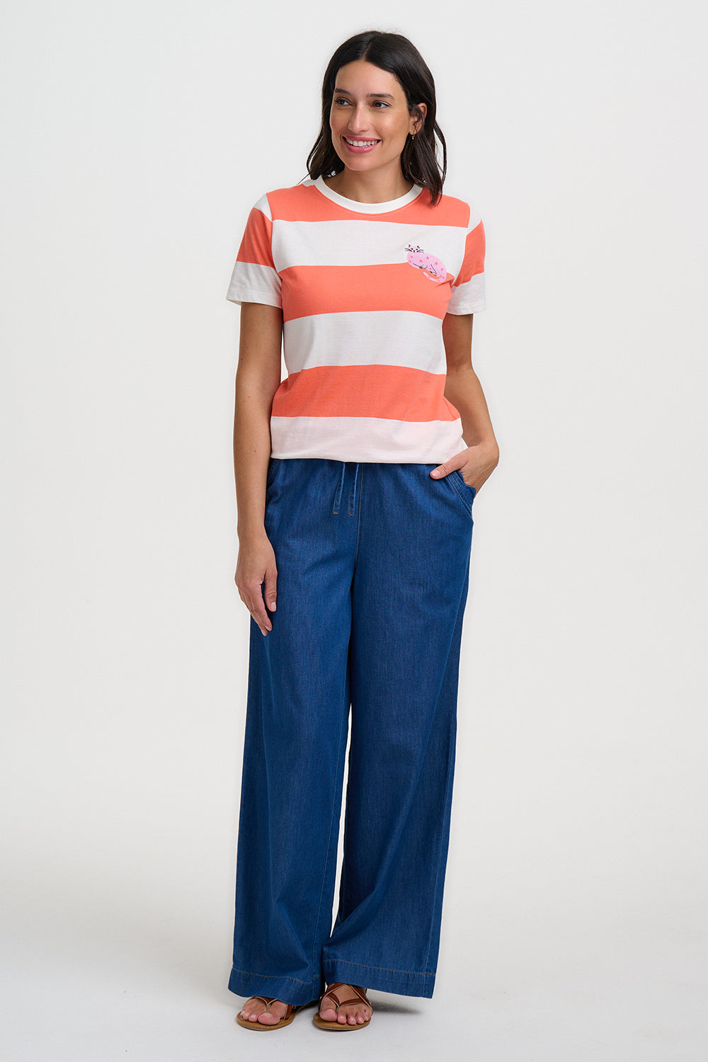 Woman wearing a striped shirt and blue pants on a white background