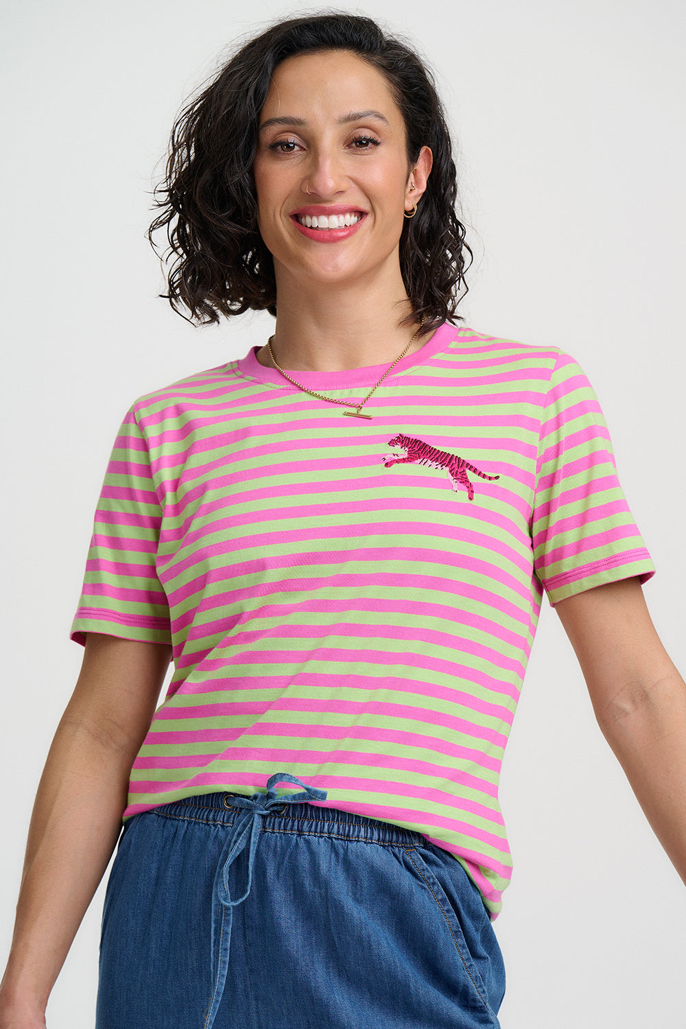 Woman wearing a pink and green striped t-shirt with a logo on a white background