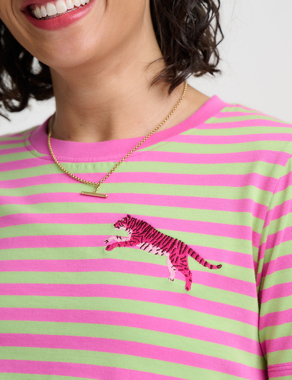Person wearing a green and pink striped shirt with a tiger design.
