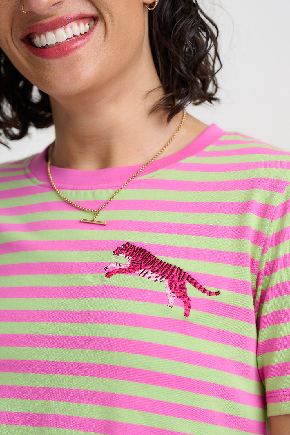 Person wearing a green and pink striped shirt with a tiger design.