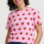Woman wearing a pink t-shirt with strawberry pattern on a white background
