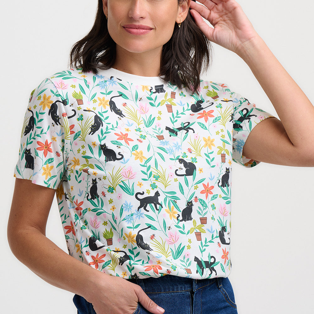 Woman wearing a colorful t-shirt with animal and floral pattern on a white background