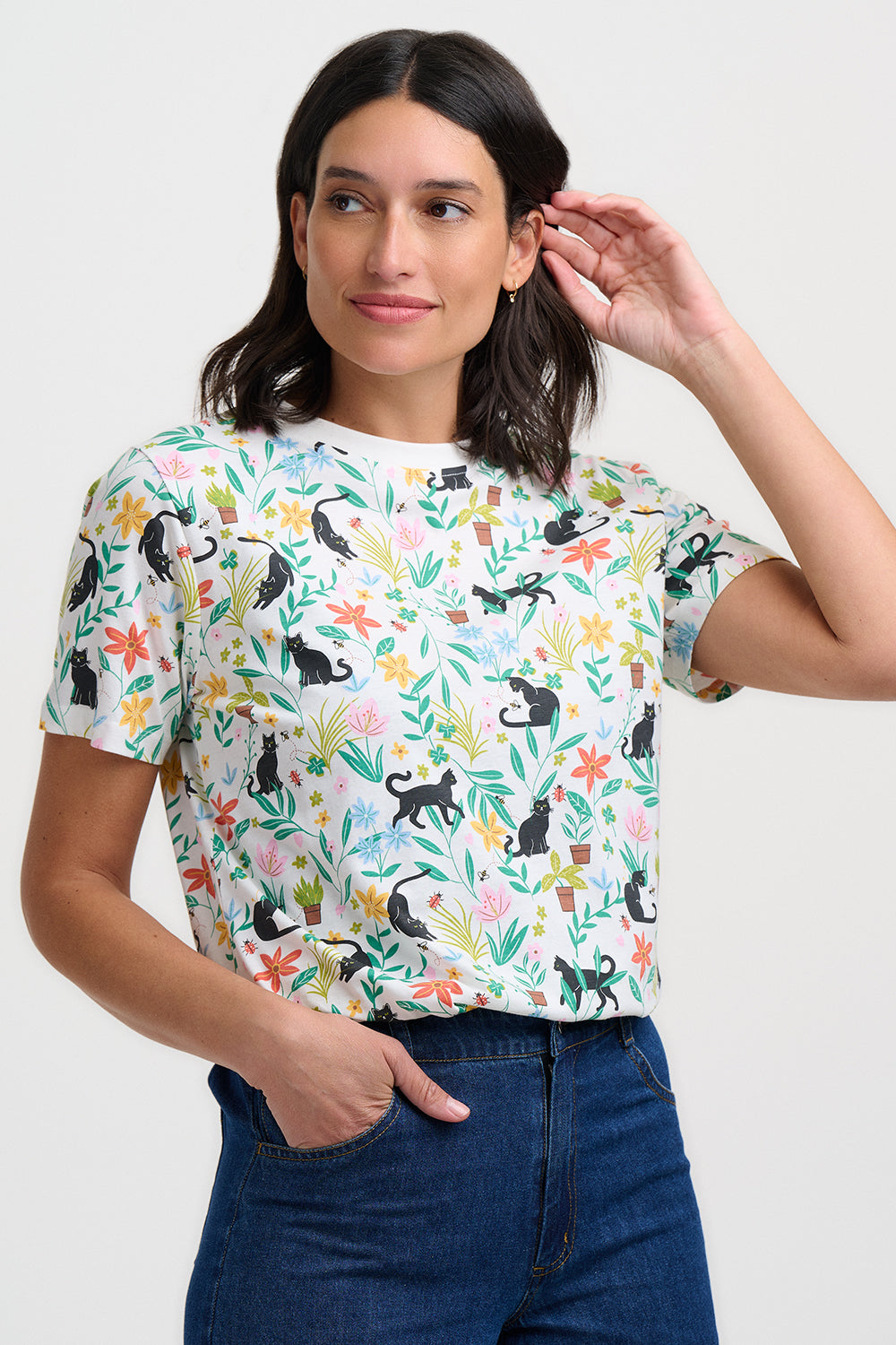 Woman wearing a colorful t-shirt with animal and floral pattern on a white background