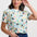 Woman wearing a colorful t-shirt with animal and floral pattern on a white background