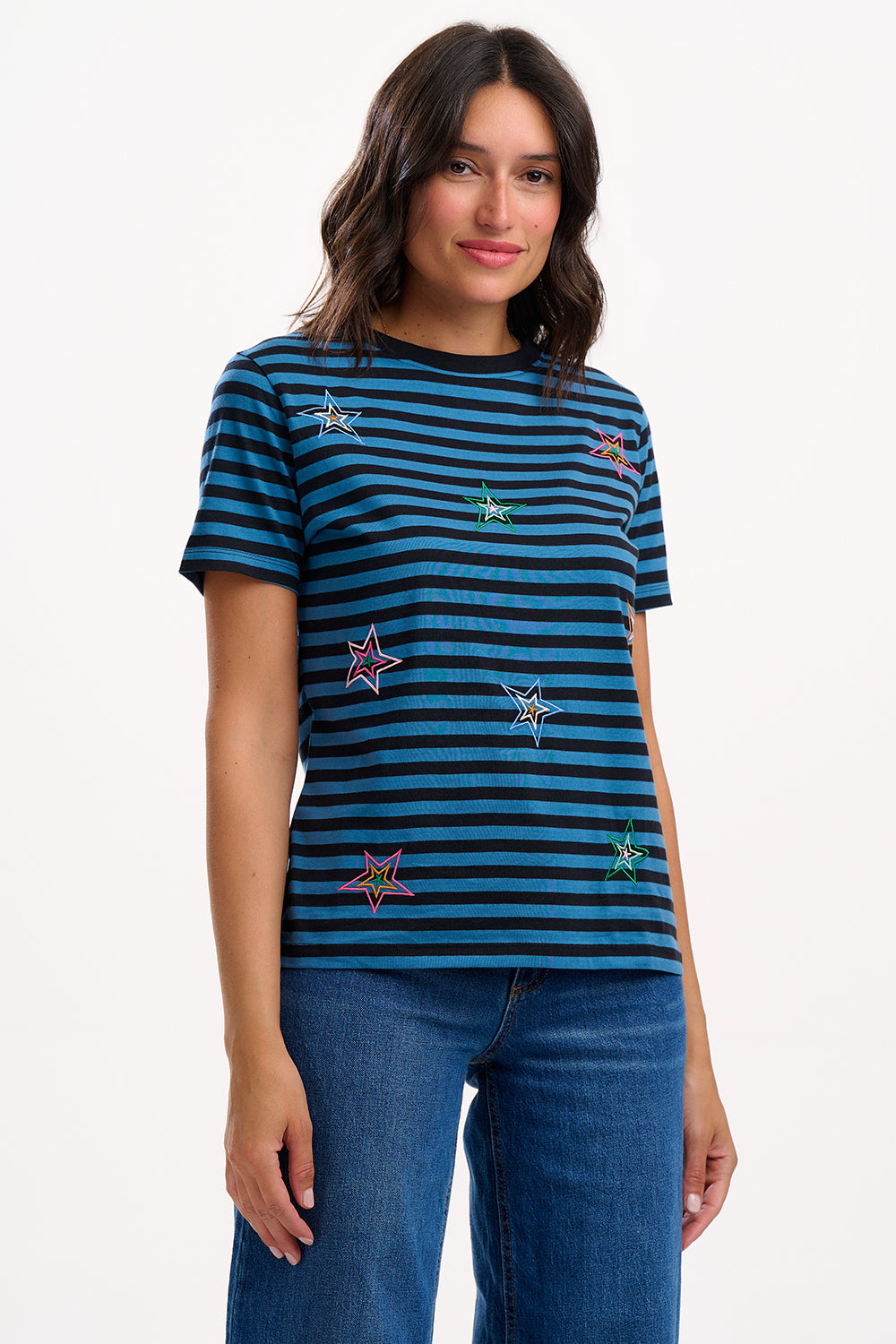 Woman wearing a blue and black striped t-shirt with embroidered designs on a white background