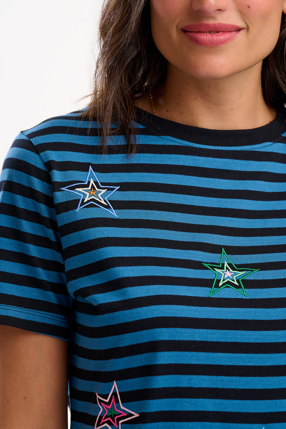 Blue and black striped t-shirt with star designs worn by a person