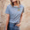 A woman wearing a blue and white striped t-shirt with a embroidered tiger on it, paired with jeans.