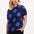 Woman wearing a navy blue top with large blue polka dots on a white background