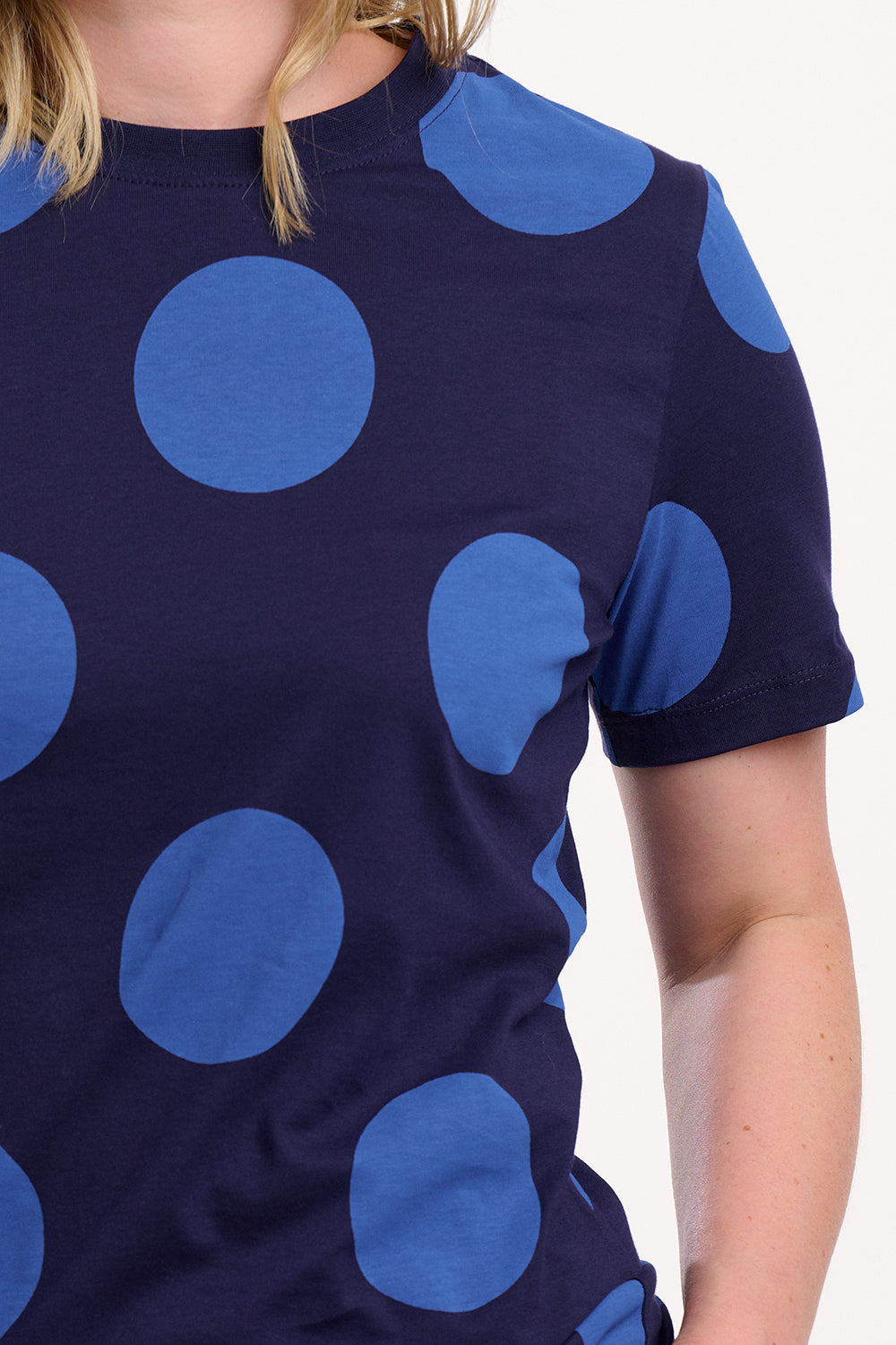 Navy blue top with large blue polka dots on a white background