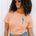 Person wearing an orange and white striped shirt with a blue parrot design, standing against a white background.
