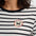 Person wearing a black and white striped shirt with a circular patch featuring a dog logo.