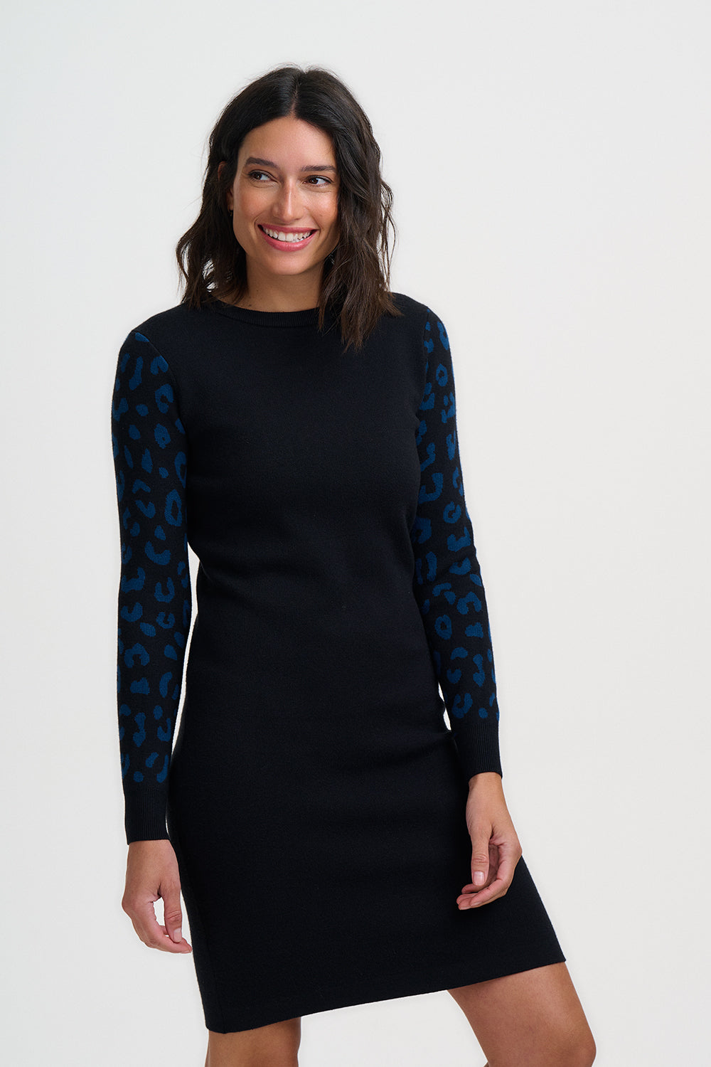 Woman wearing a black dress with blue patterned sleeves on a white background
