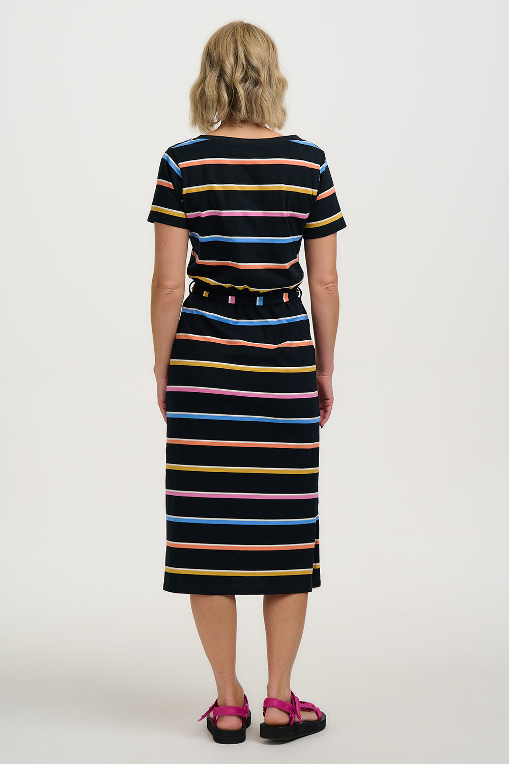 Person wearing a black and multicolor striped dress on a white background