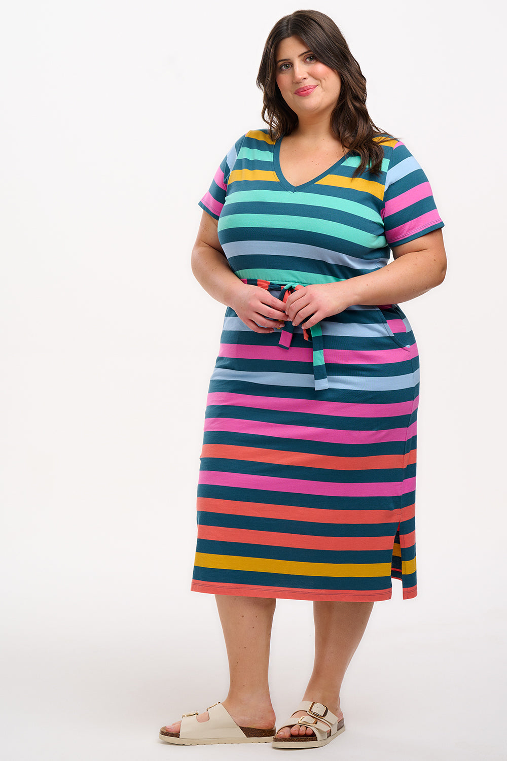 A model wearing a midi-length V-neck dress with stripes in green and other colors, featuring a matching tie belt.