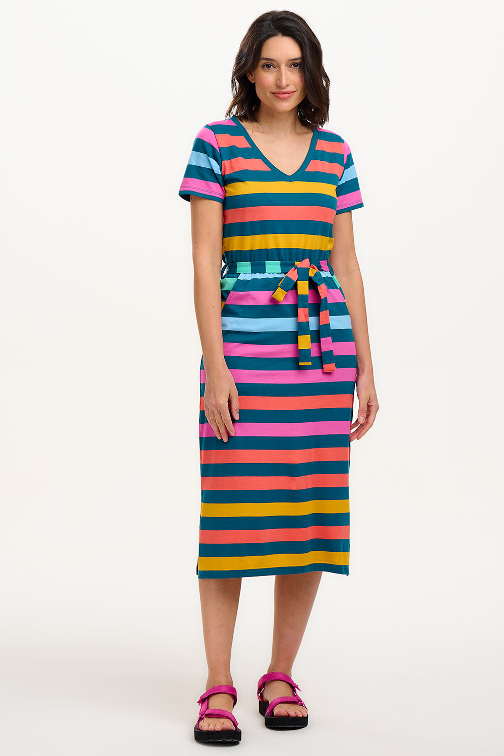 A model wearing a midi-length V-neck dress with stripes in green and other colors, featuring a matching tie belt.