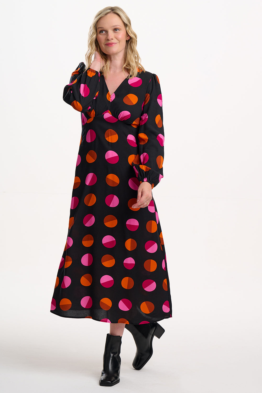 Woman wearing a black dress with colorful polka dots on a white background