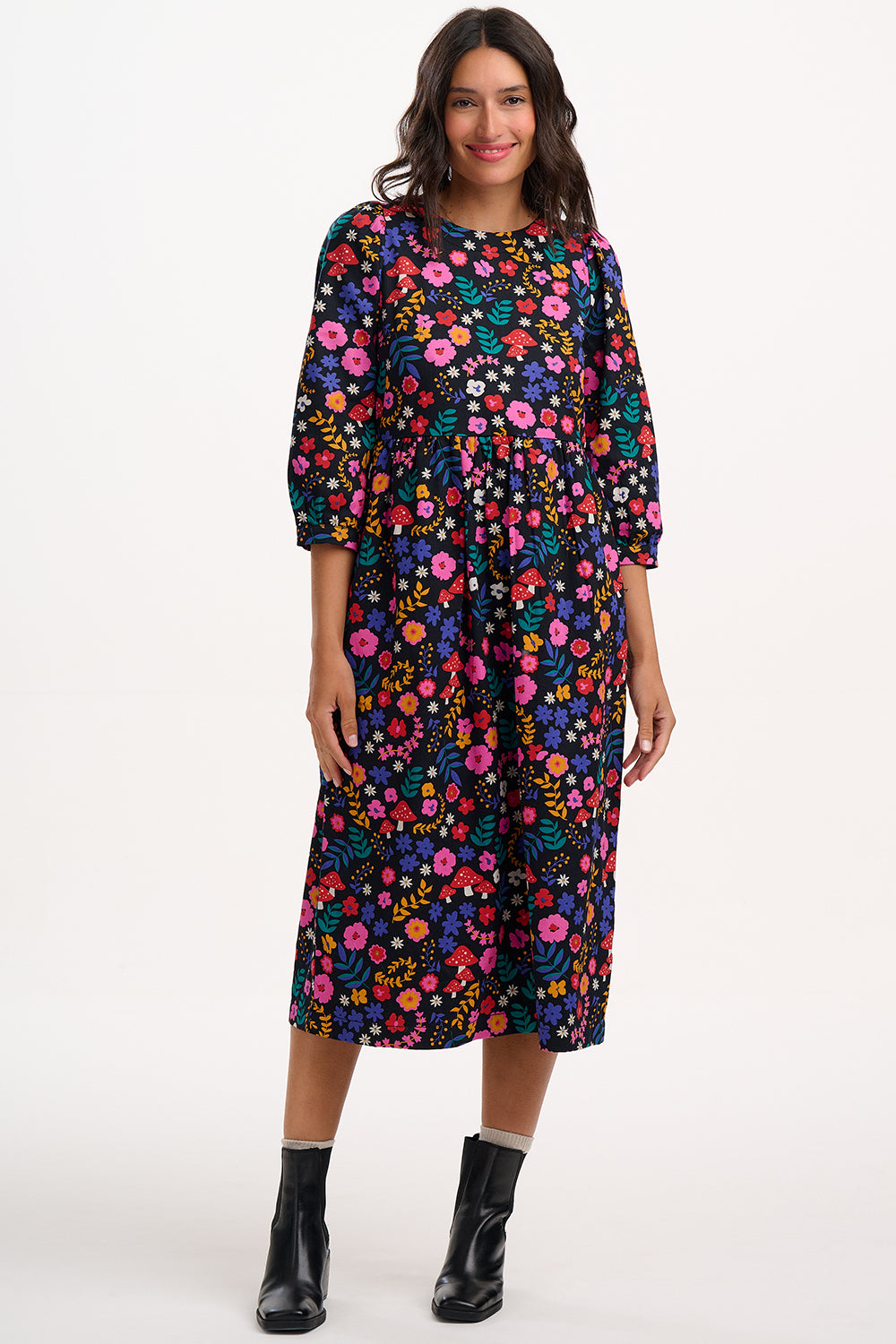 Woman wearing a colorful floral dress on a white background