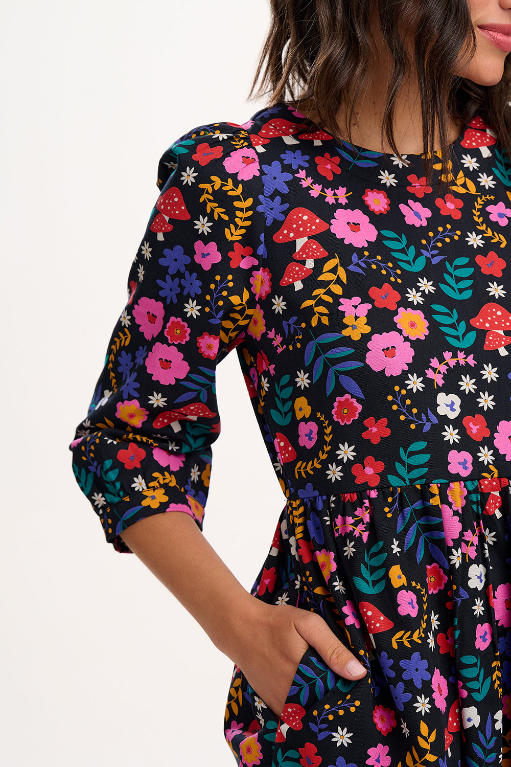 Woman wearing a colorful floral dress with a white background