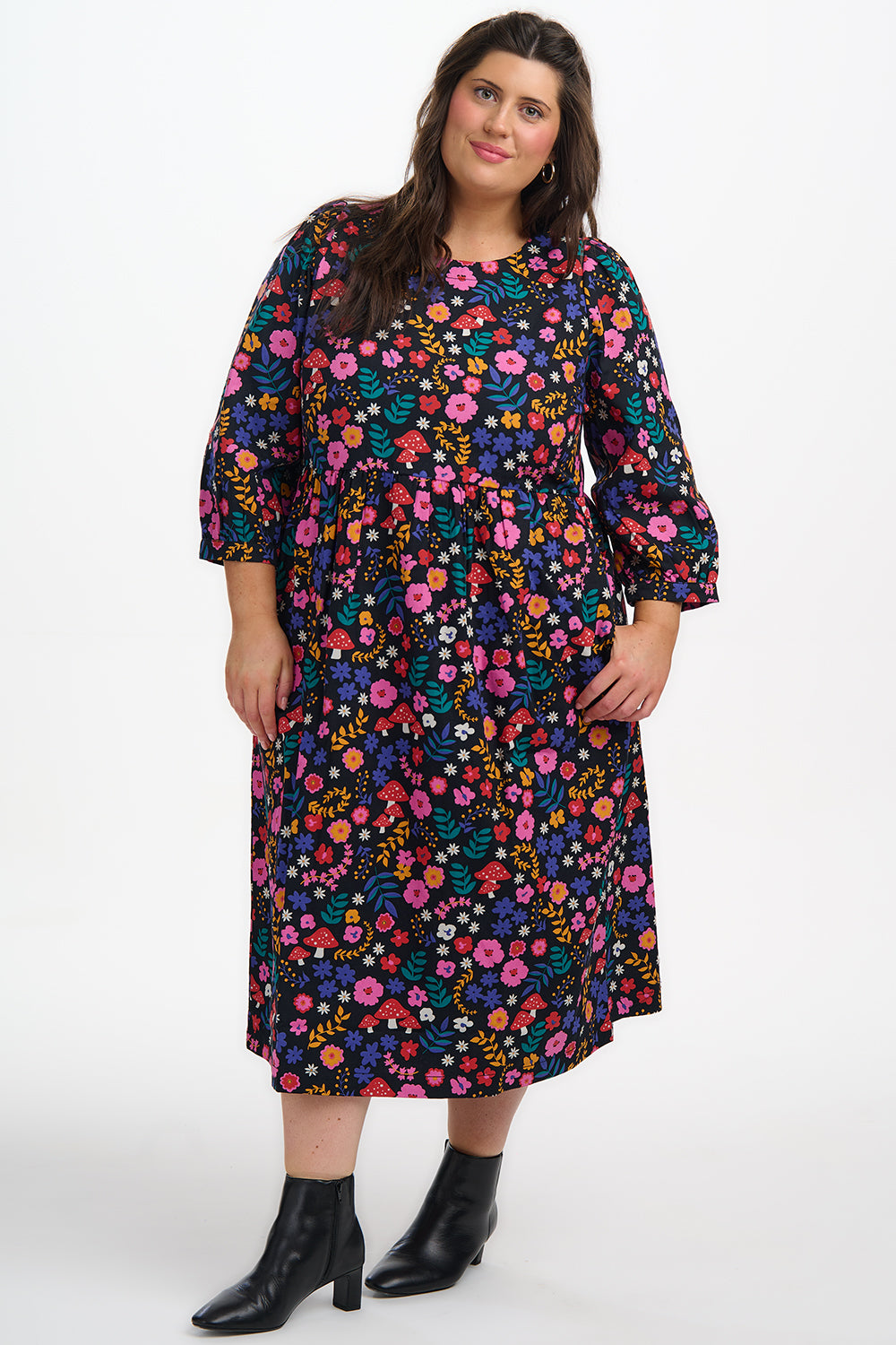 Woman wearing a colorful floral dress on a white background