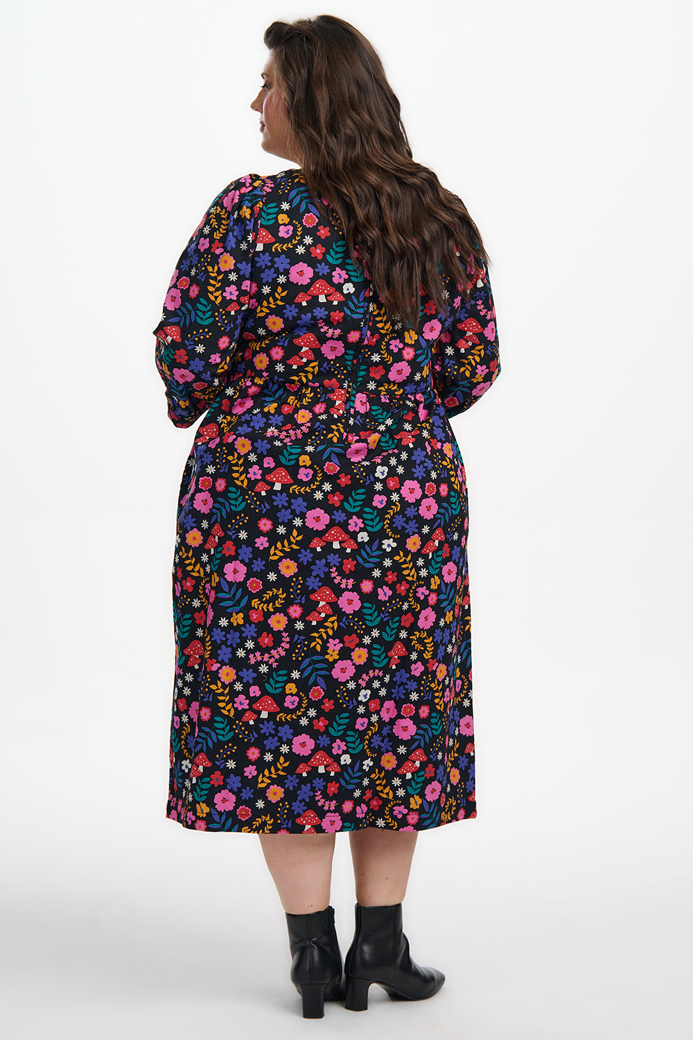 Woman wearing a colorful floral dress on a white background