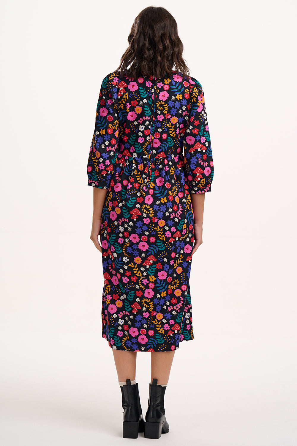 Woman wearing a colorful floral dress on a white background