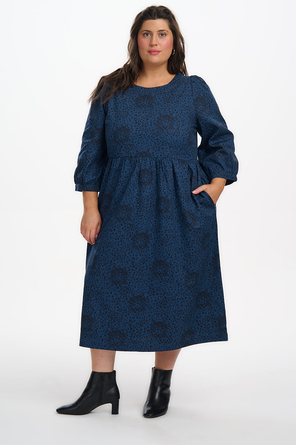 Woman wearing a blue dress with a pattern on a white background