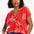 A woman modeling a red blouse with a tropical leaf print, featuring a round grandad collar and cap sleeves.