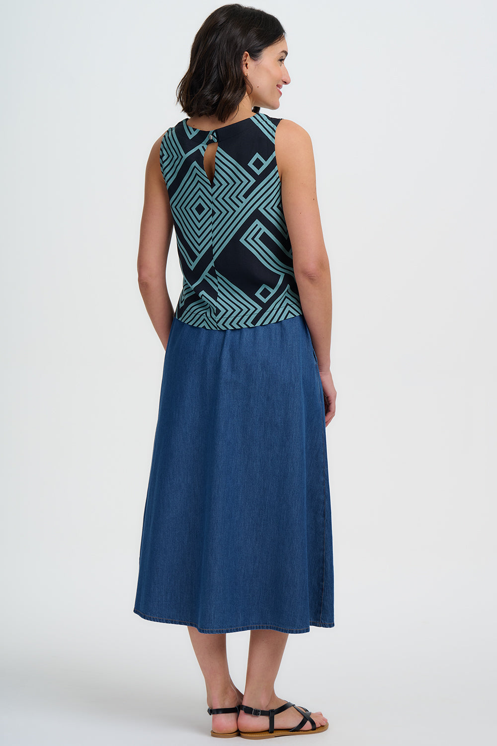 Woman wearing a blue dress with a geometric pattern on a white background