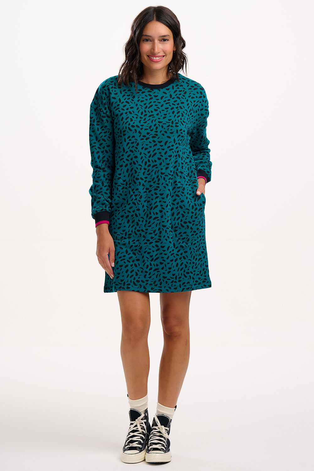 Sugarhill Brighton Model wearing a teal dress with black pattern on a white background