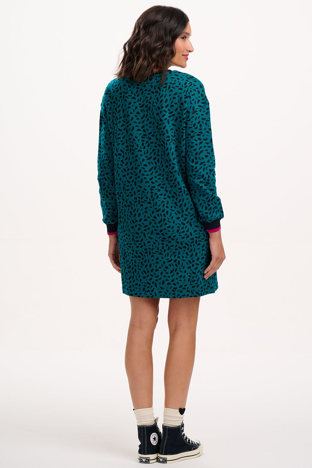 Sugarhill Brighton model wearing a teal patterned dress on a white background