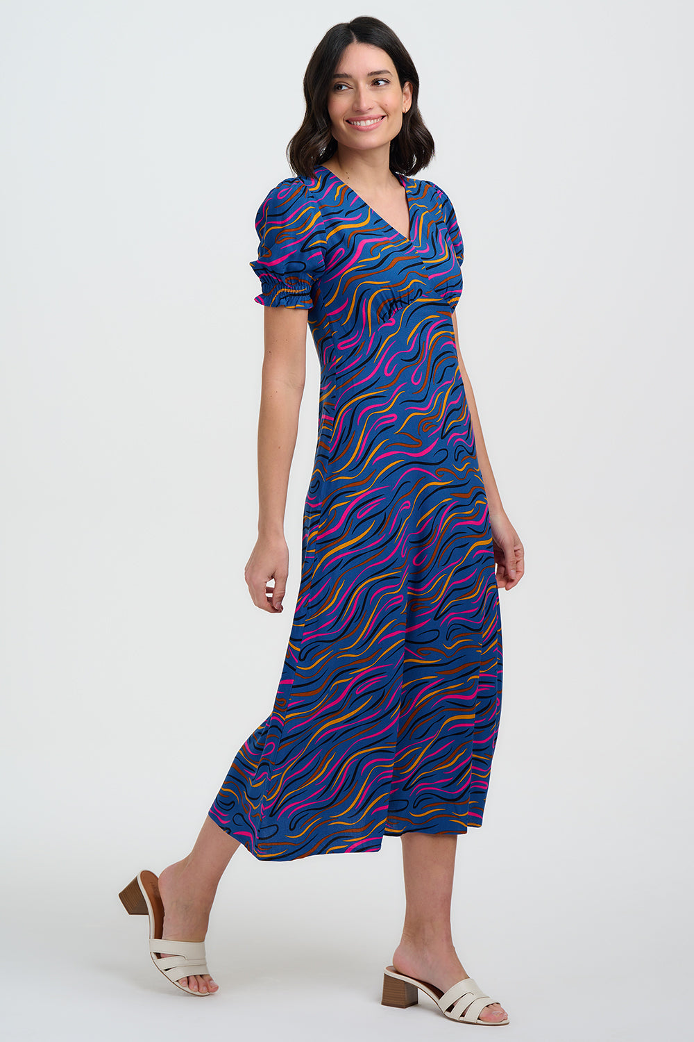 Woman wearing a colorful dress with wavy pattern on a white background