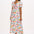 A model wearing an off-white midi dress with a tropical hummingbird print, featuring a V-neck and short shirred cuffs.