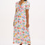A model wearing an off-white midi dress with a tropical hummingbird print, featuring a V-neck and short shirred cuffs.