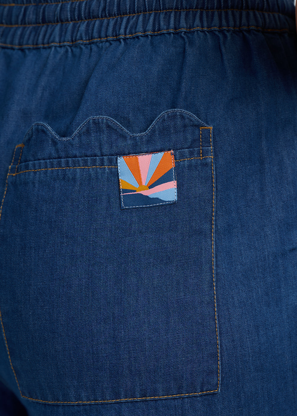 Blue denim pocket with a colorful patch on a blue denim background