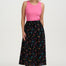 Woman wearing a pink top and black floral skirt on a white background