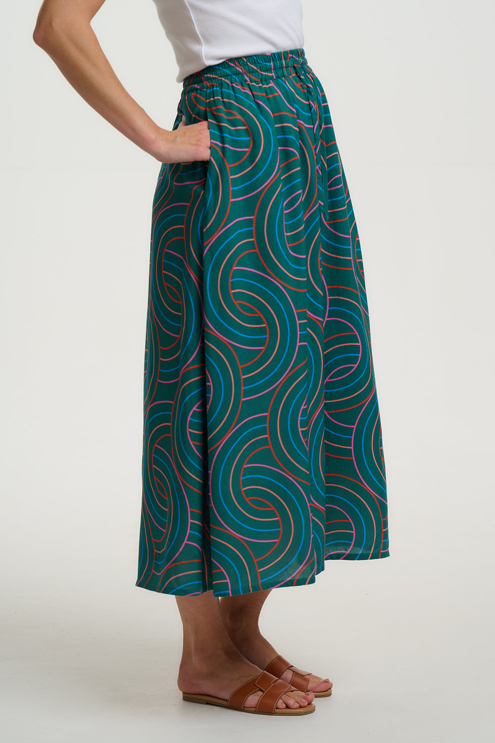 Person wearing a green patterned skirt on a white background