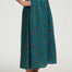Person wearing a green patterned skirt on a white background